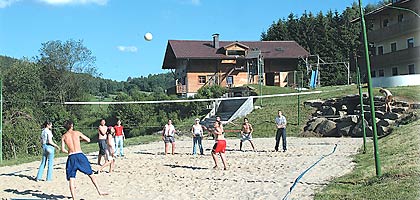Schüler beim Volleyball vor der Berghütte